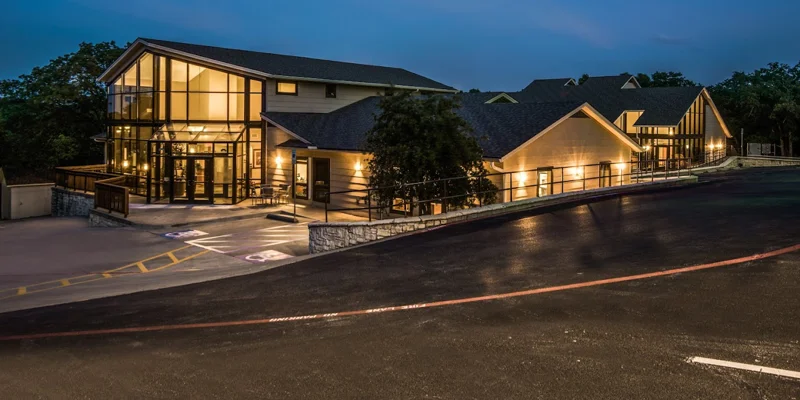 Modern rehab facility with glass walls, lit at night