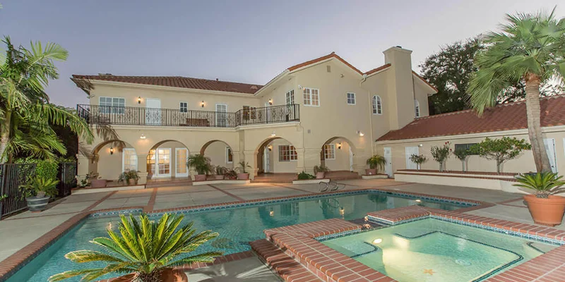 Villa with a pool, spa, and landscaping.