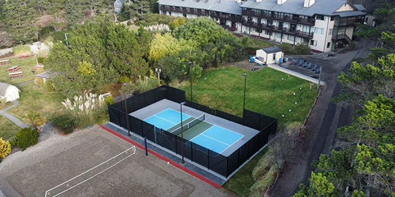 Outdoor recreational area with pickleball and volleyball courts.