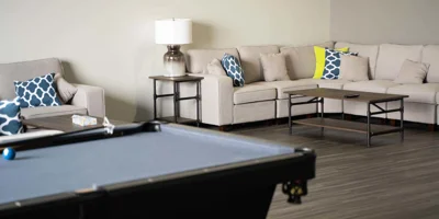 A cozy beige sectional couch with blue and yellow pillows in a lounge area.