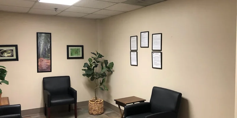 Waiting area with chairs, wall art, and potted plant