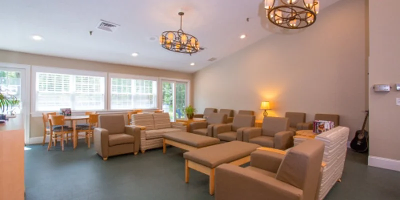 A lounge area with cushioned chairs, tables, and warm lighting.