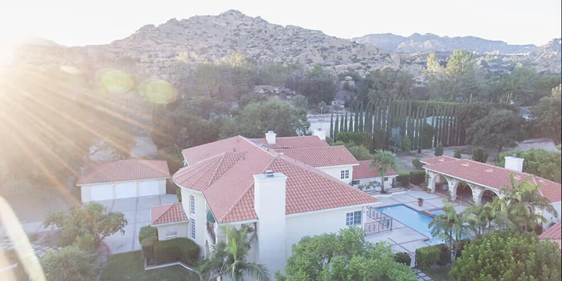 Aerial view of a facility with a pool, and greenery.