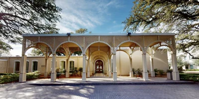 A grand arched entrance with a paved driveway.