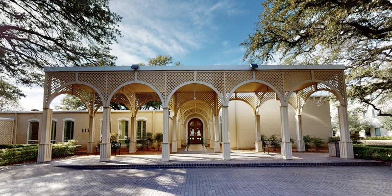 A grand arched entrance with a paved driveway.