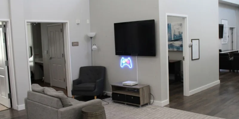  Game area with  seating, and a neon game controller sign,