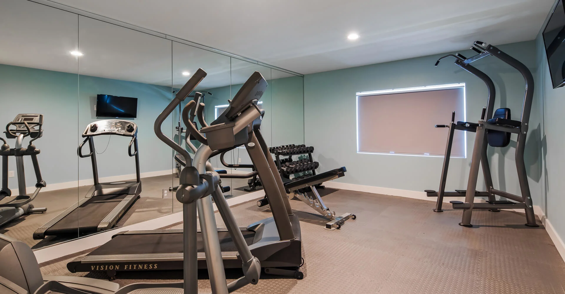 Gym with treadmills, weights, and exercise machines.
