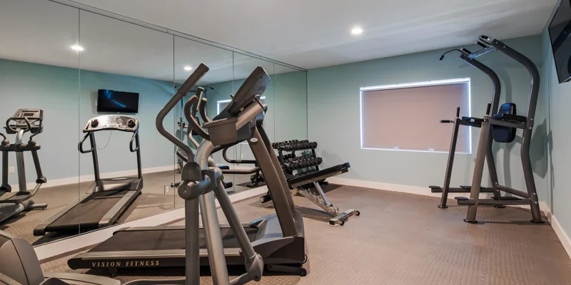 Gym with treadmills, weights, and exercise machines.