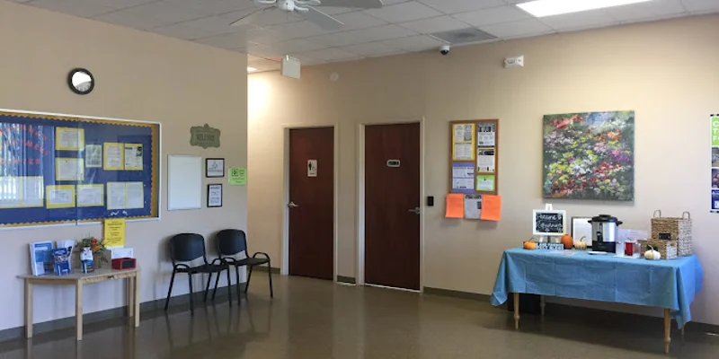 Waiting area with chairs and a refreshment table.