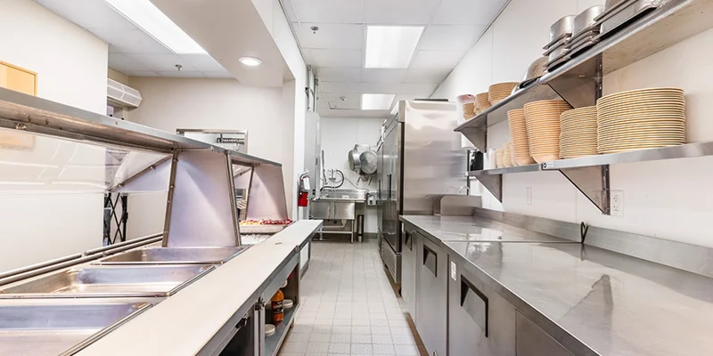 Commercial kitchen with serving counter and stainless appliances