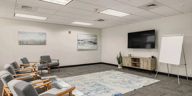 Group therapy room with chairs and a TV.