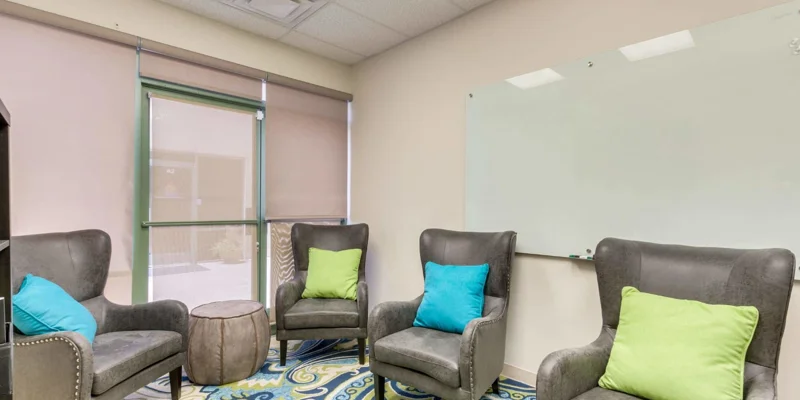Group therapy room with chairs andlarge window.