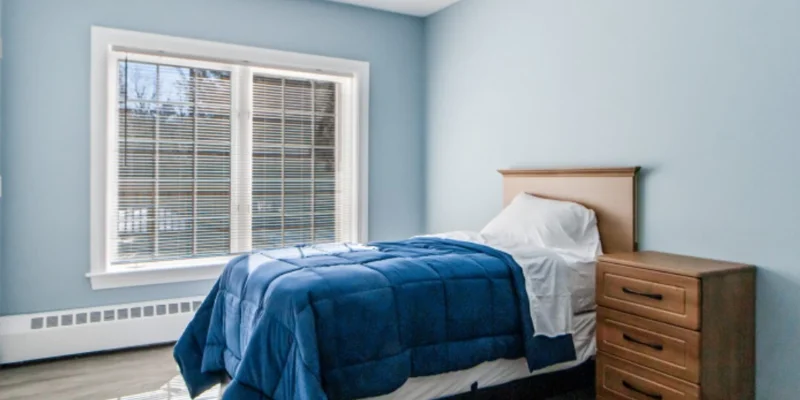 Bedroom with a bed and a wooden nightstand next to it.