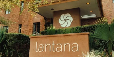 Lantana Recovery entrance sign with greenery and brick building.
