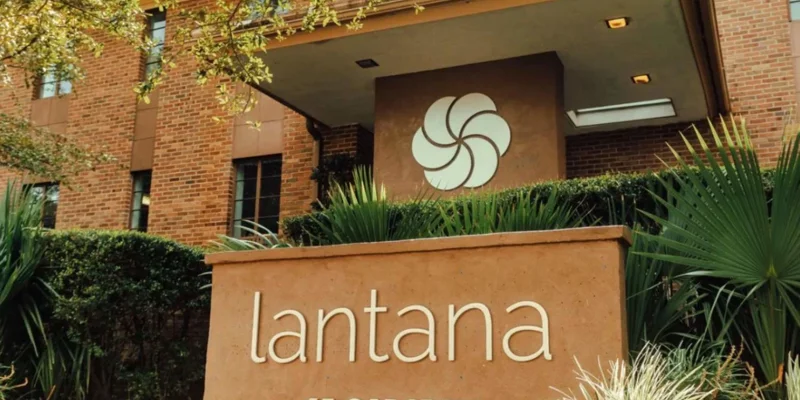 Lantana Recovery entrance sign with greenery and brick building.