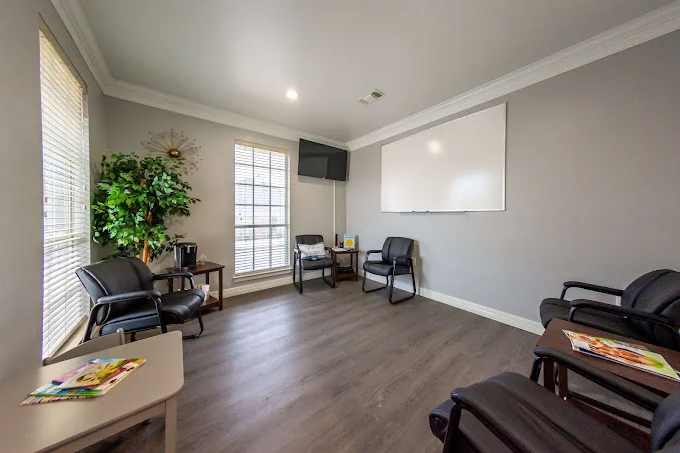 Group meeting room with black chairs and a whiteboard.