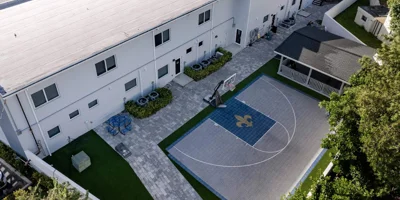 Aerial view with a basketball court and shaded seating area.