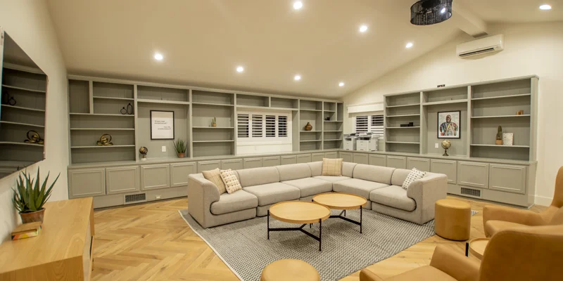 A spacious lounge with built-in shelves and a large sectional sofa.