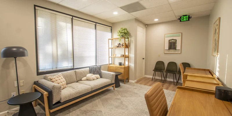 Cozy lounge with a modern gray sofa, desk, and warm lighting