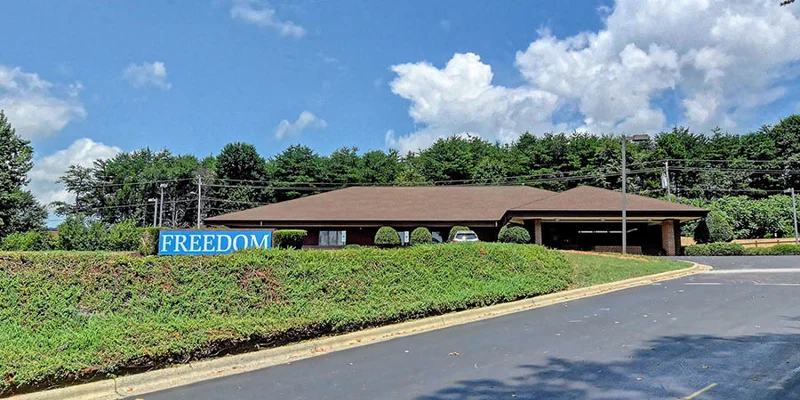 One-story building with hedges and Freedom sign
