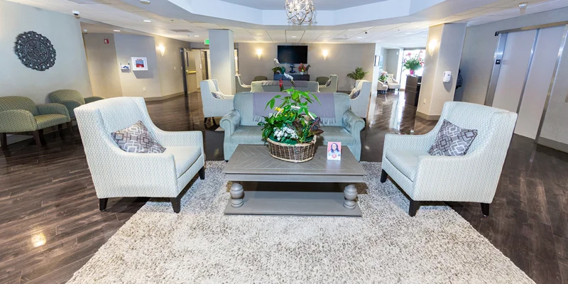 A lobby with elegant seating, soft lighting, and a chandelier