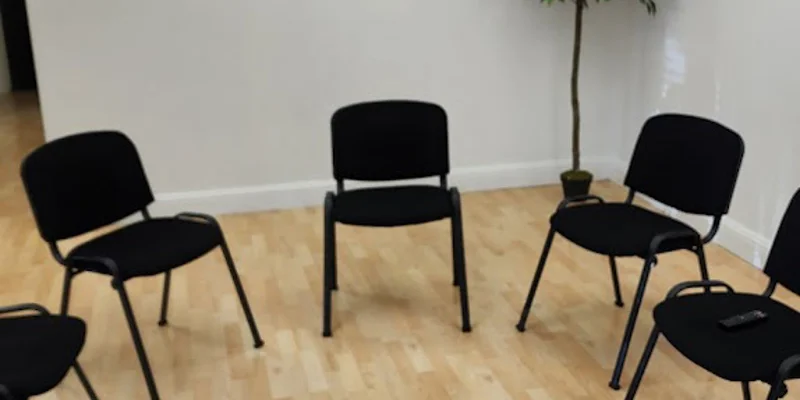 Group therapy room with black chairs in a circle.