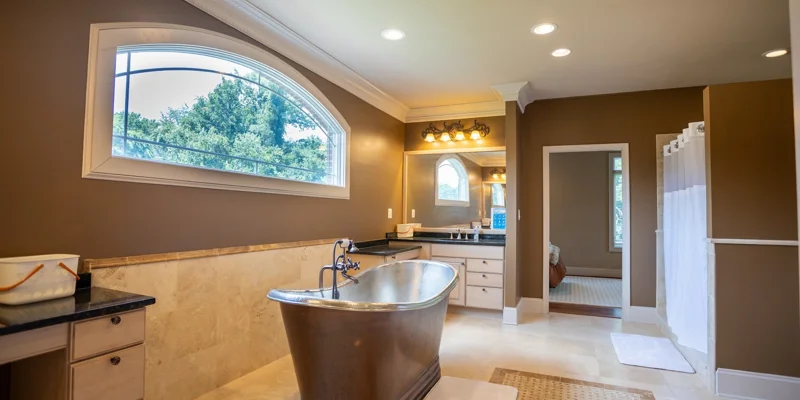 A spacious bathroom with a soaking tub and a large window