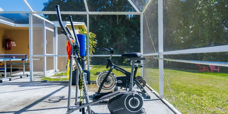 Exercise bike and elliptical on a screened patio