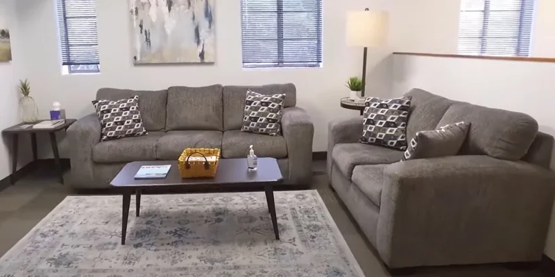 A cozy lounge with gray sofas, a coffee table, and decorative pillows