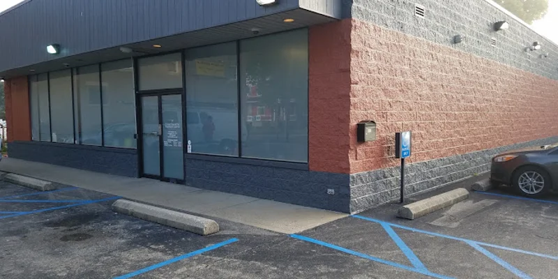 A waiting area with chairs, a bulletin board, and an open office door.