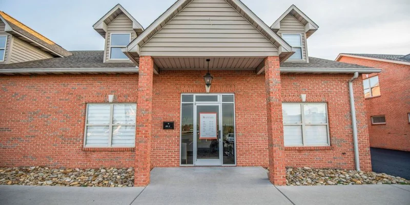 Brick building with glass entryway and sign above door