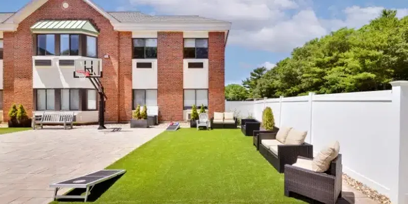 Outdoor recreation area with seating and a basketball hoop.