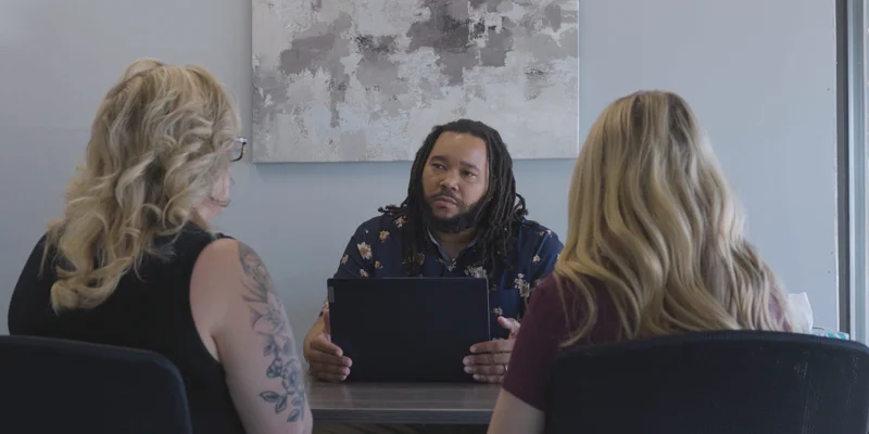 A counselor meeting with two clients.