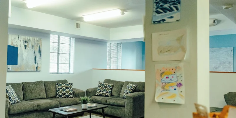 A lounge area with sofas, framed artwork, and a coffee table