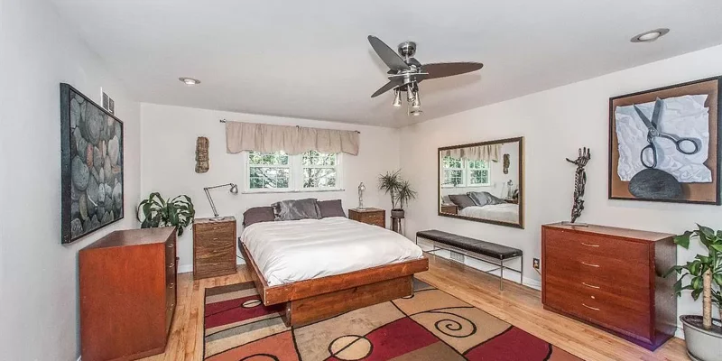 Private bedroom with bed, side-tables, and large mirror.