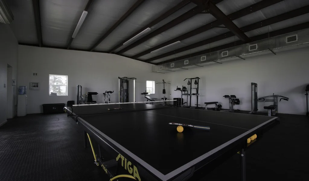 Gym with a ping pong table and equipment.
