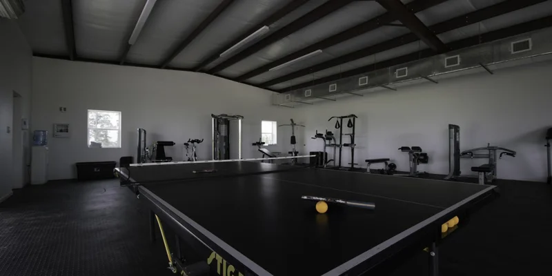 Gym with a ping pong table and equipment.
