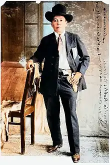 Photo of Robles from a newspaper leaning against a chair with a cigarette in his hand (colorized)