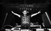 A picture of a DJ acknowledging the audience