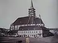 Church with adjacent buildings, new tower under construction (1850)