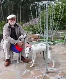 Ed Headrick with his two whippets with a new DGA disc golf lightweight all metal disc golf target. Photo taken in 2002 two months before he died.
