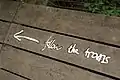 The trail is marked with metal direction signs, designed to look hand-written