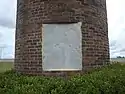 A brick pedestal with a stone plaque which reads: “This monument to the peanut, Turner County's most important agricultural product, is dedicated to the memory of Nora Lawrence Smith, December 25, 1886 - July 17, 1971. Member, Georgia Journalism's Hall of Fame, Editor and Co-Publisher of the Wiregrass Farmer, Turner County's Award Winning Newspaper and an untiring supporter of Turner County and its agricultural economy."