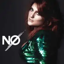 A young woman with red hair and a green top is looking straight at the camera. To her right stands the title, no.
