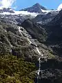 The Hirere Falls on the  Milford Track are on the south western extreme of the Wick Mountains. The peaks behind at up to 1,920 metres (6,300&nbsp;ft) do not have official names.