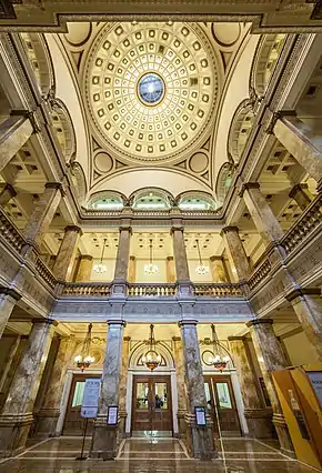 The elegant interior of the dome and rotunda, including marble pillars, arches, ornate fixtures, and a mosaic floor.