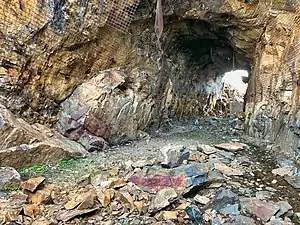 2018 photograph of Needle's Eye Tunnel, near the summit of Rollins Pass. This view shows the northeast portal in the foreground; the southwest portal can be seen in the background. Wire mesh and metal dowels were installed in August 1987 to help reduce additional rock falls and preserve the condition of the tunnel constructed in 1903 (121 years ago) (1903).