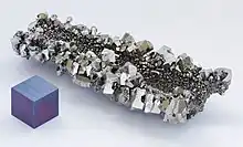 Niobium crystals and a 1&nbsp;cm3 anodized niobium cube for comparison