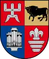 A coat of arms divided into four sections, the top left and bottom right of which are red, the bottom left of which is blue, and the top right of which is golden
