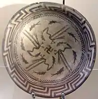 Samarra plate, with a design consists of a rim, a circle of eight fish, and four fish swimming towards the center being caught by four birds, at the center being a swastika symbol; circa 4000 BCE; painted ceramic; diameter: 27.7&nbsp;cm; Vorderasiatisches Museum (Berlin)